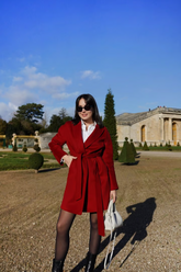 a lady in a white shirt and a red wrap coat